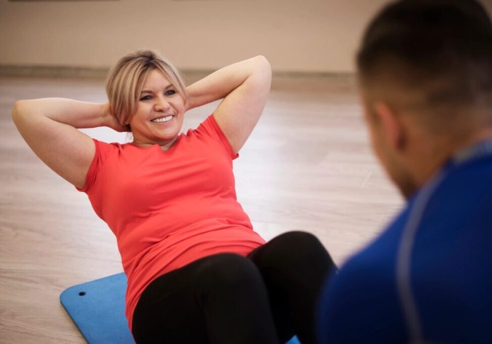 A woman is doing sit ups on the floor